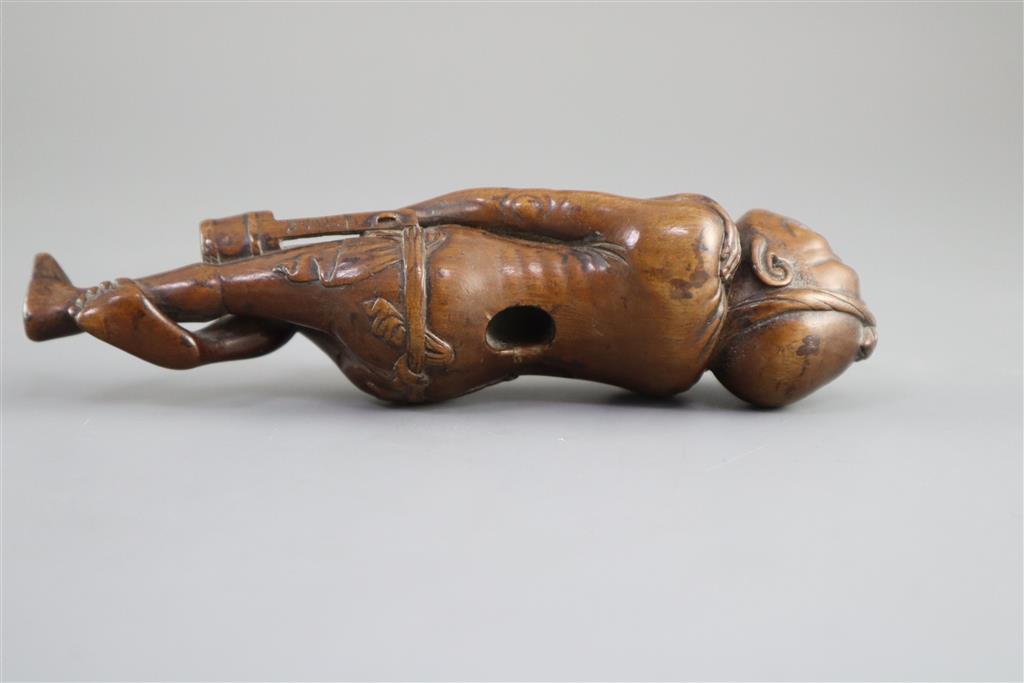 A Japanese cherrywood okimono netsuke of a farmer, early 19th century, 15cm long